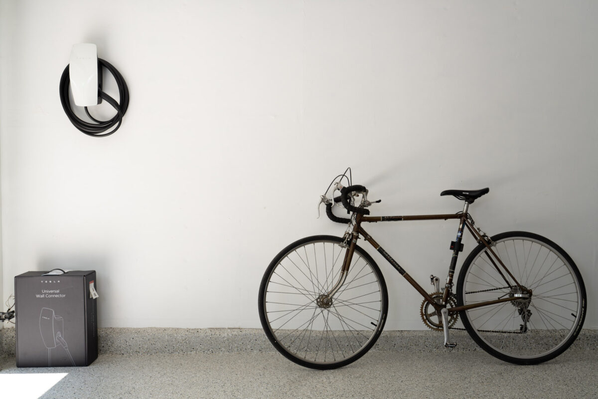 Tesla EV Charger on white wall and bicycle 