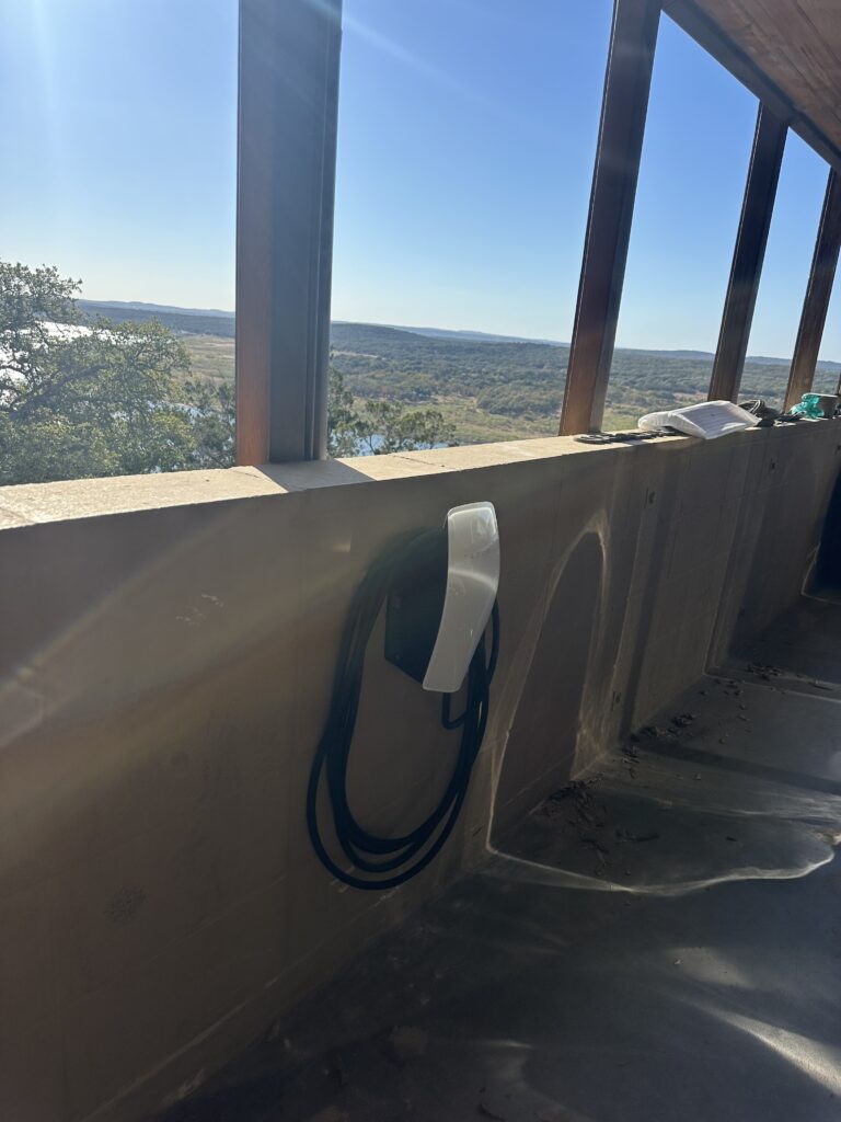 Tesla Wall Connector on a porch wall overlooking the Texas Hill Country
