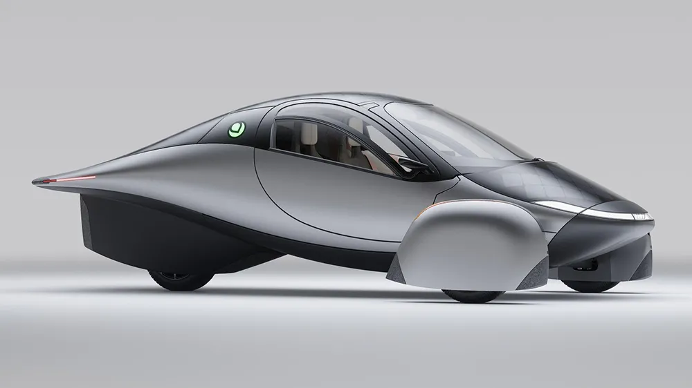 Aptera solar electric vehicle: sleek white three-wheeled EV with full-body hexagonal solar panel array under a panoramic glass canopy, aerodynamic teardrop design, green Aptera logos. Futuristic render.