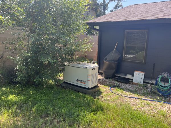 home standby generator installation in backyard near utility building