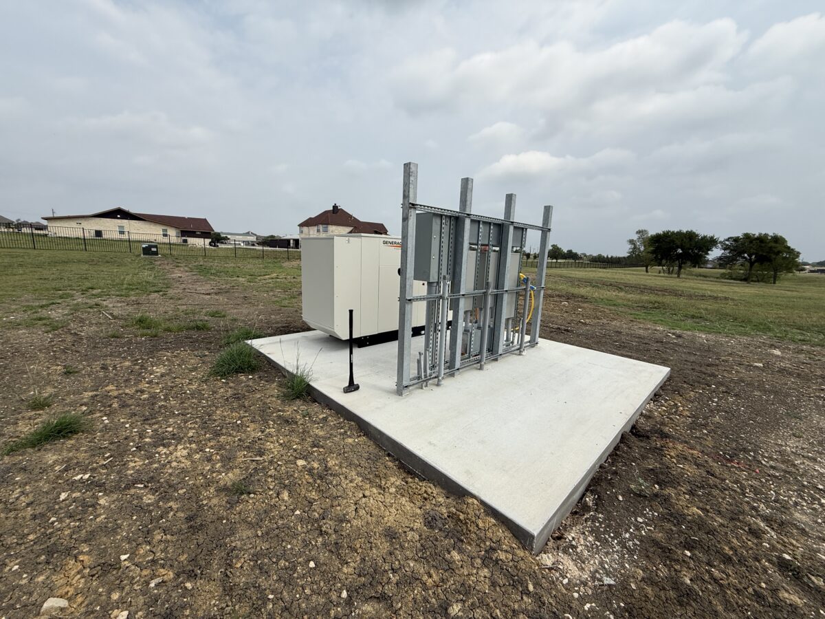Whole-home generator on a concrete pad with electrical service equipment