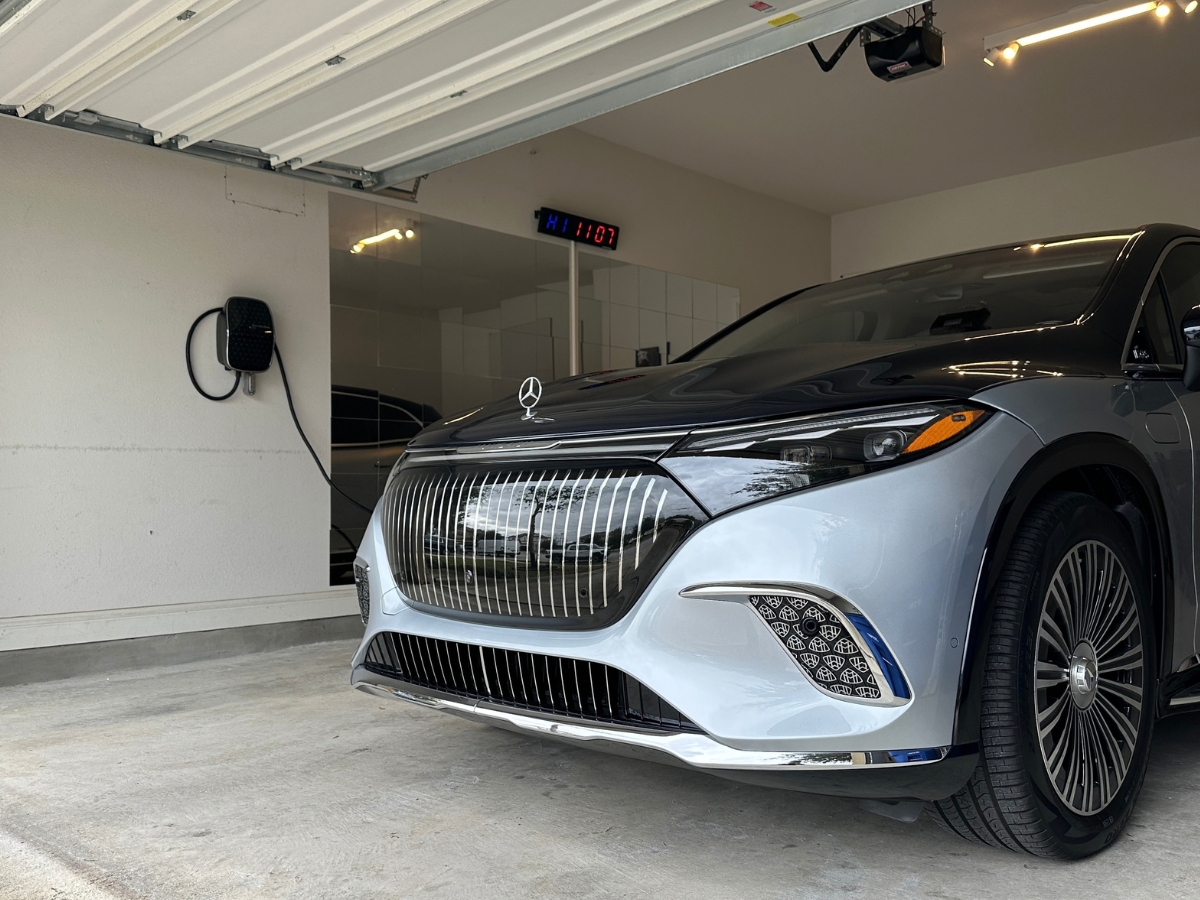 Wall-mounted EV charger in a garage next to a Mercedes-Benz EQS