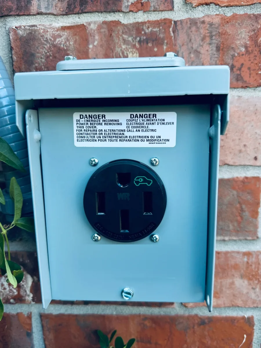 EV-rated NEMA 14-50 outlet in an outdoor weatherproof enclosure on a brick wall