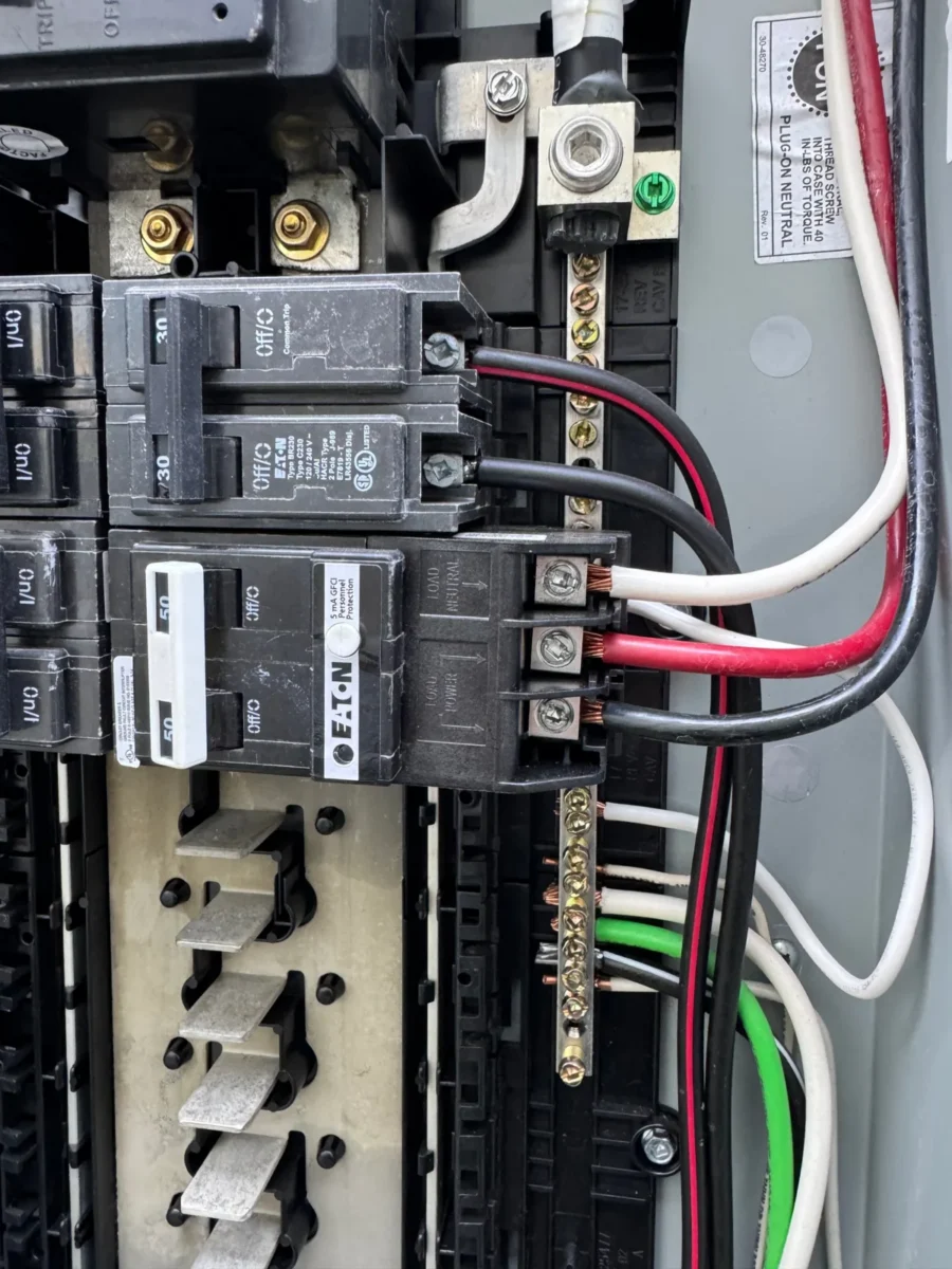 Standard two-pole breaker above a two-pole GFCI breaker with a test button and 5 mA label in a residential panel