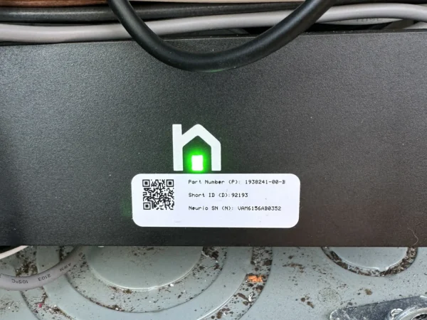 Tesla energy meter built by Neurio with a green status light, installed in a Texas home electrical panel for EV charger load management