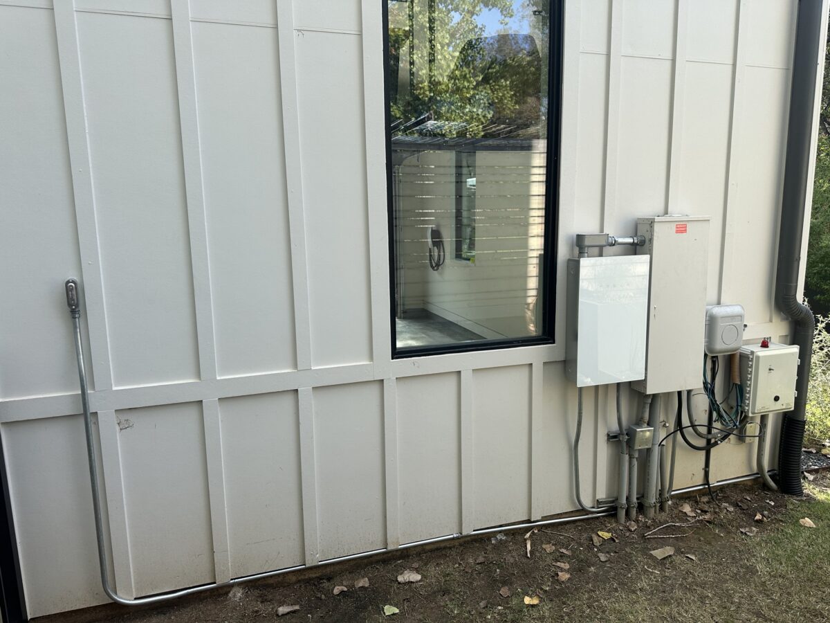 Tesla Powershare and Powerwall equipment on the side of a West Austin home